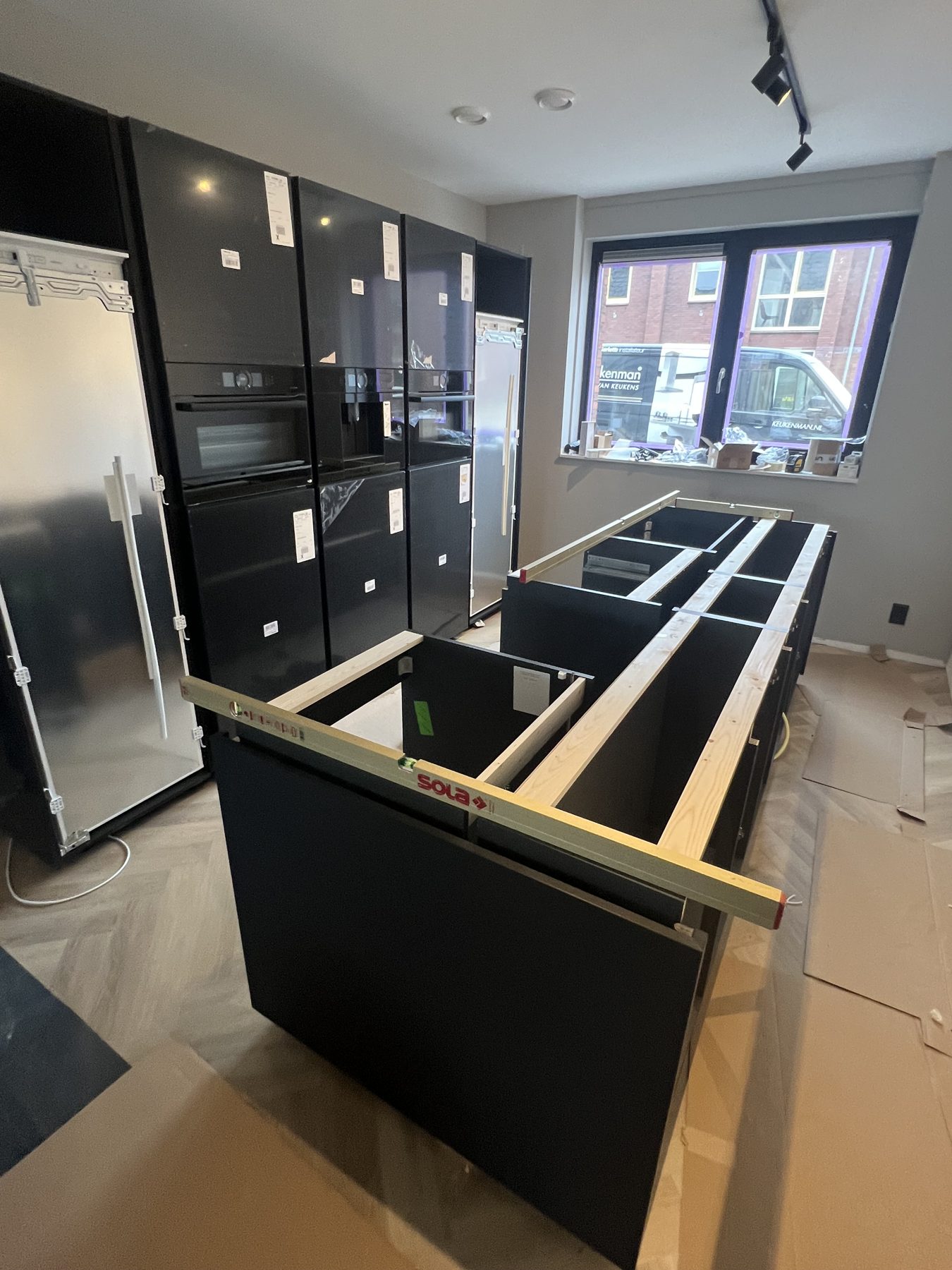Kookeiland in opbouw met waterpas op de kastframes